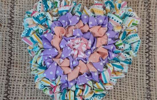 A colourful fabric broach in the shape of a heart.