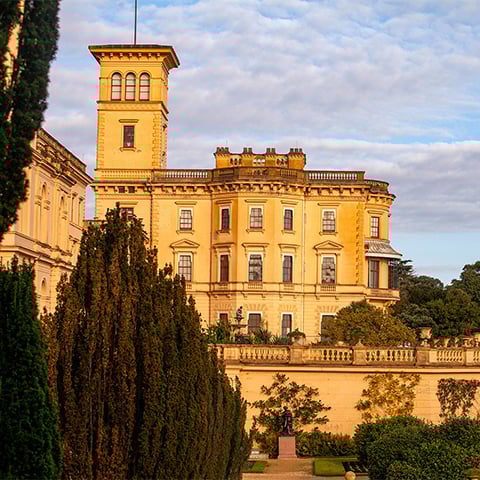 The clock tower and palatial looking Osborne glowing amber in the evening sun