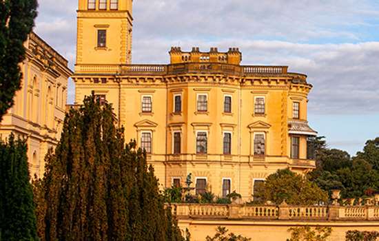 The clock tower and palatial looking Osborne glowing amber in the evening sun