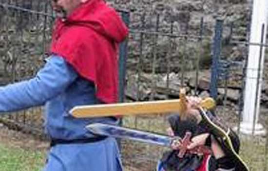 Two men yield swords dressed in blue and red medieval costumes.