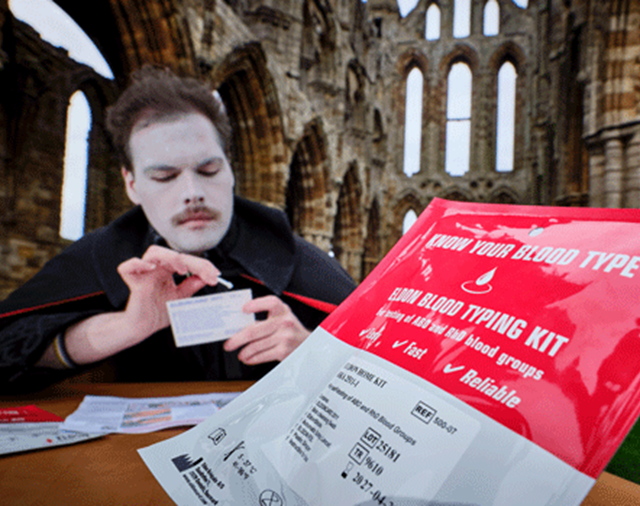 Image: an actor dressed as Dracula tests his blood type at Whitby Abbey